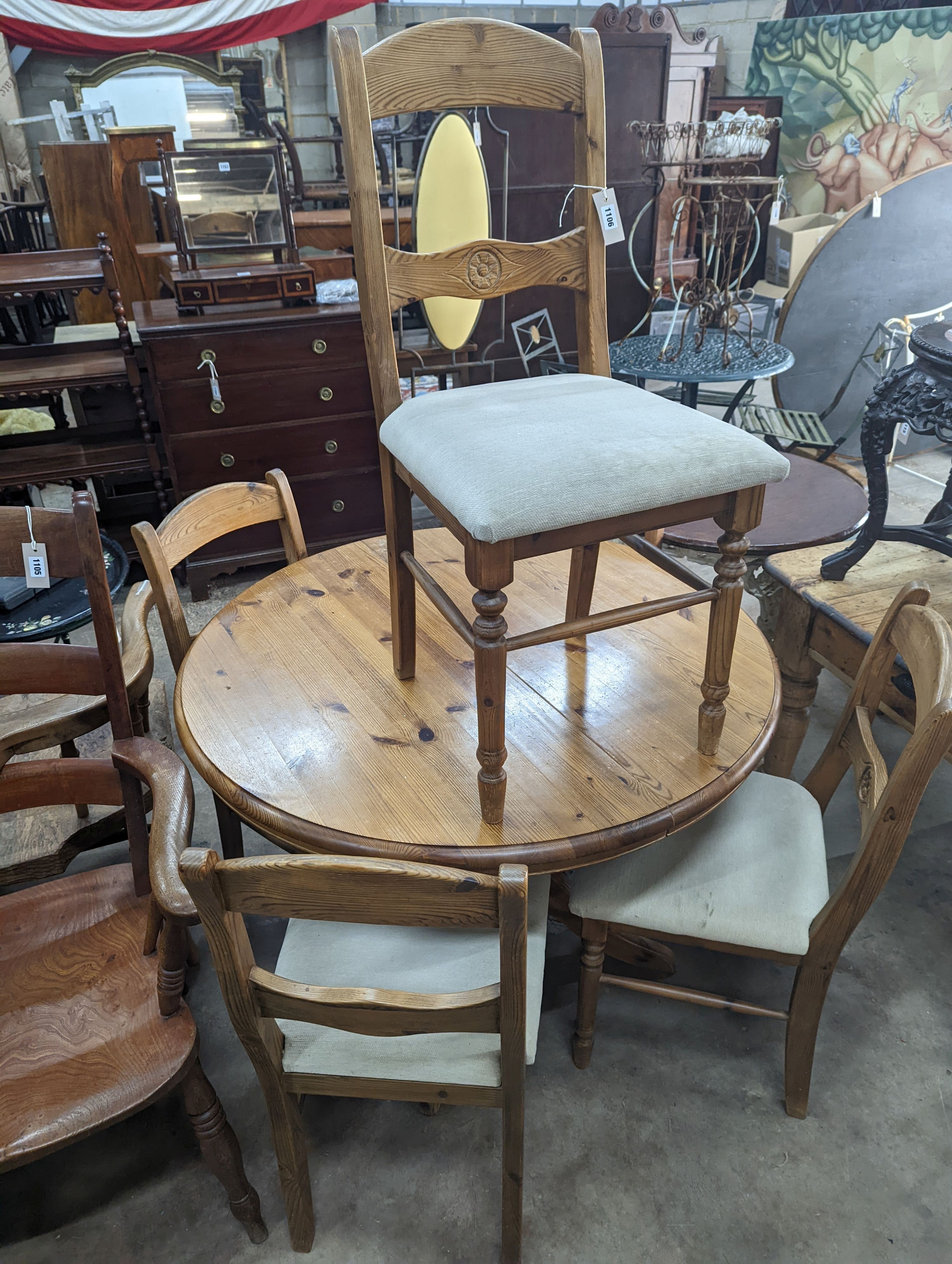 A reproduction circular pine breakfast table, diameter 105cm, height 77cm together with five pine dining chairs